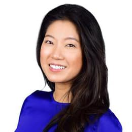 Headshot of Jane Choi, who is smiling and has long straight black hair. She wears a bright blue top.